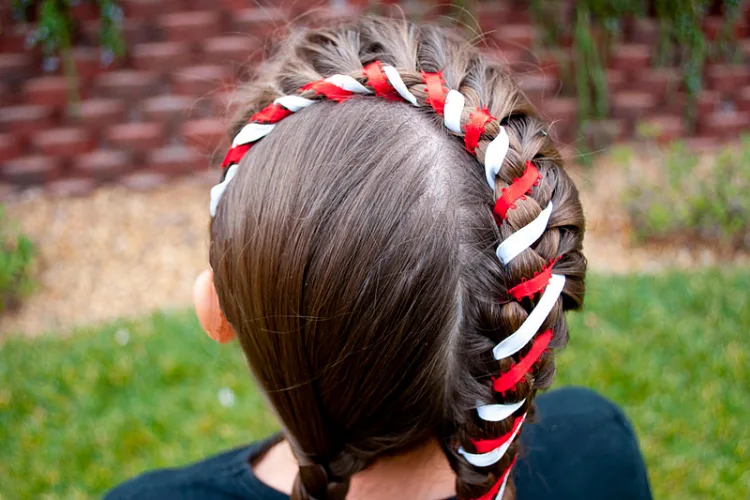braided hairstyle for little girls candy cane ribbon attached to the hair cute festive look