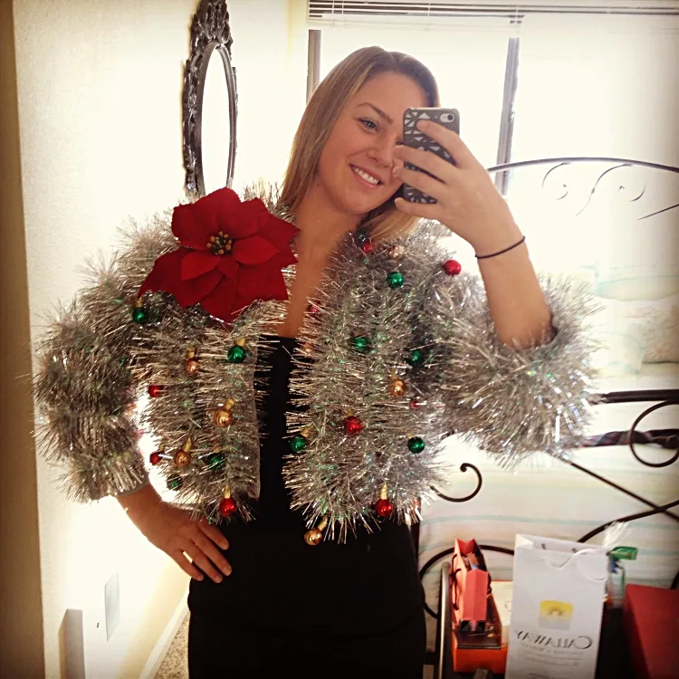 creative idea for an ugly christmas cardigan out of silver tinsel garland tree ornaments artificial poinsettia