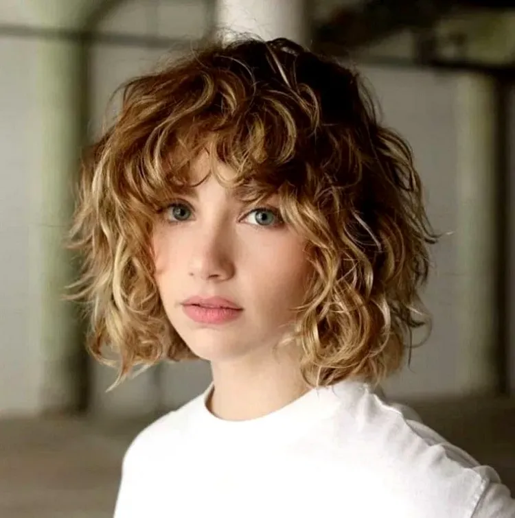 curly messy short bob idea with bangs blonde hair with highlights