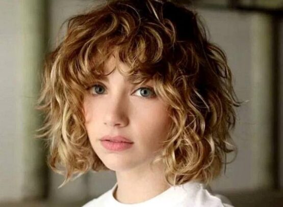 curly messy short bob idea with layered bangs blonde hair with highlights