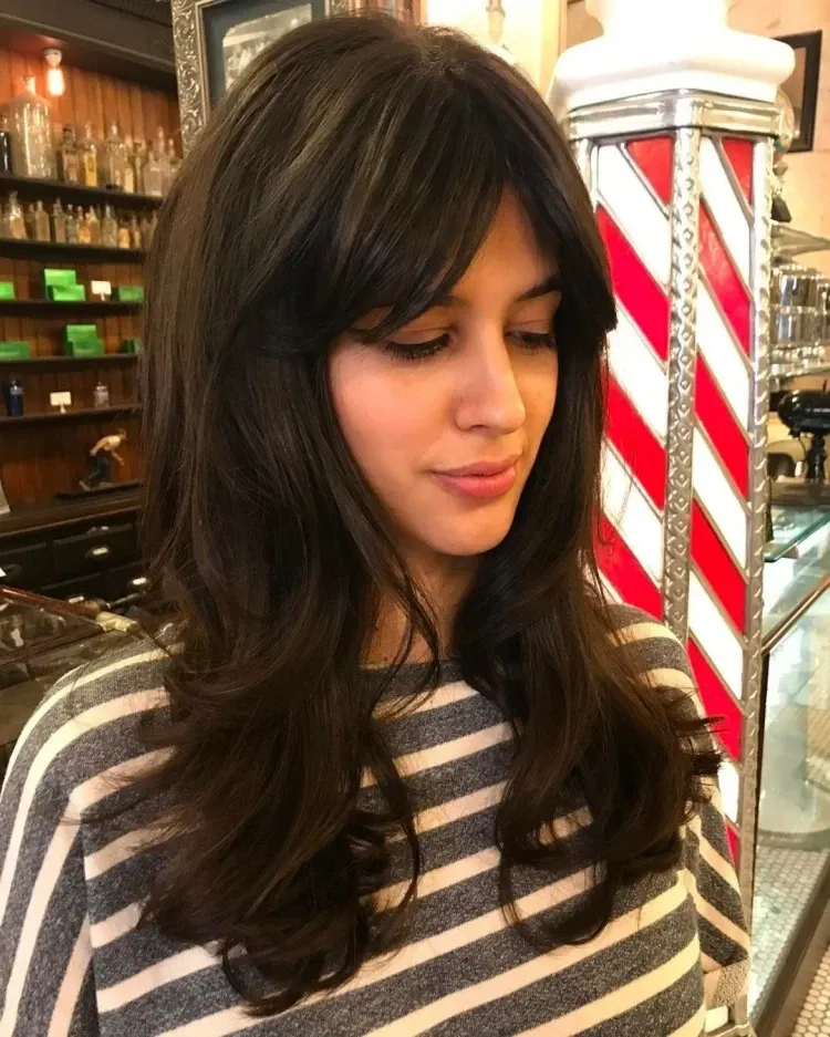 cute u-shaped haircut with curtain bangs curly hair with layers