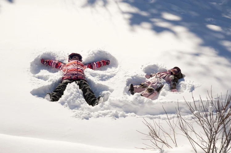 winter activities for kids making snow angels two kids having fun in the snow