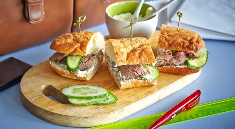 roash beef sandwich cut into three with sour cream and cucumbers tasty and easy recipe