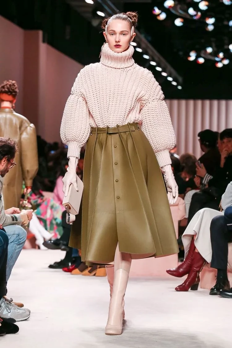 Combine an oversized sweater with a leather skirt for winter 2023