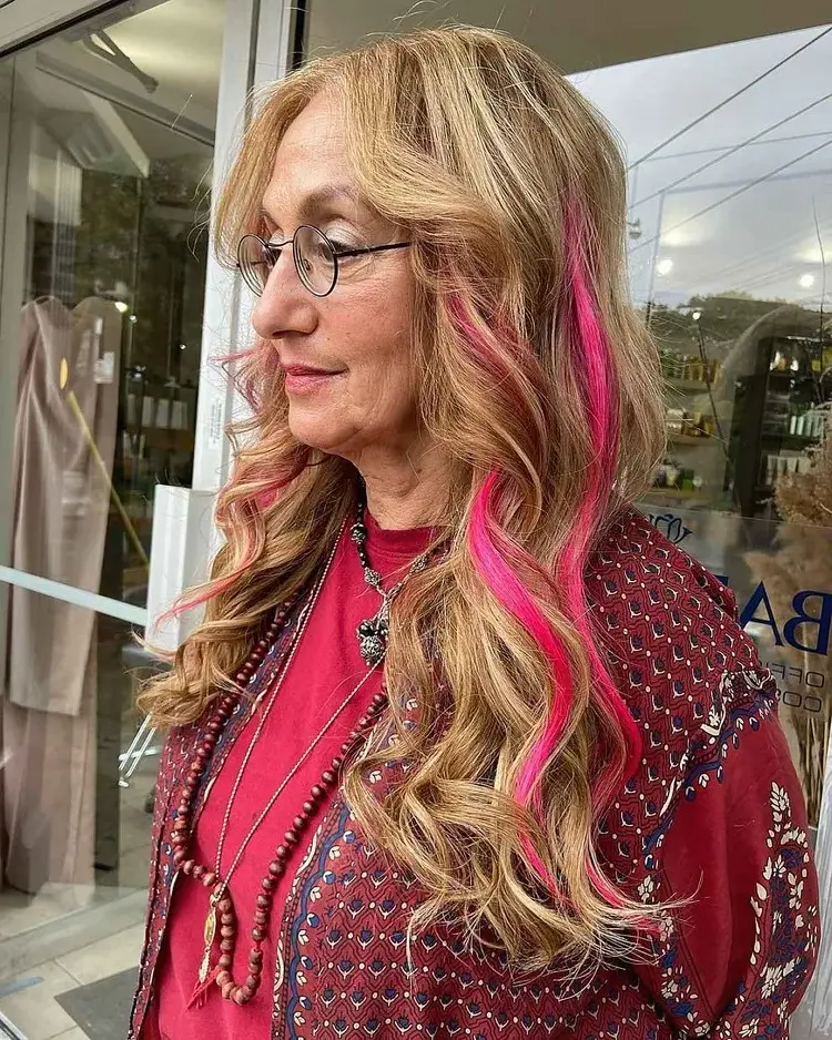 peluqueria-mujer-70-años-con-gafas-tendencia-coloracion-cabello-largo-con-cortina-cabello-viva-magenta