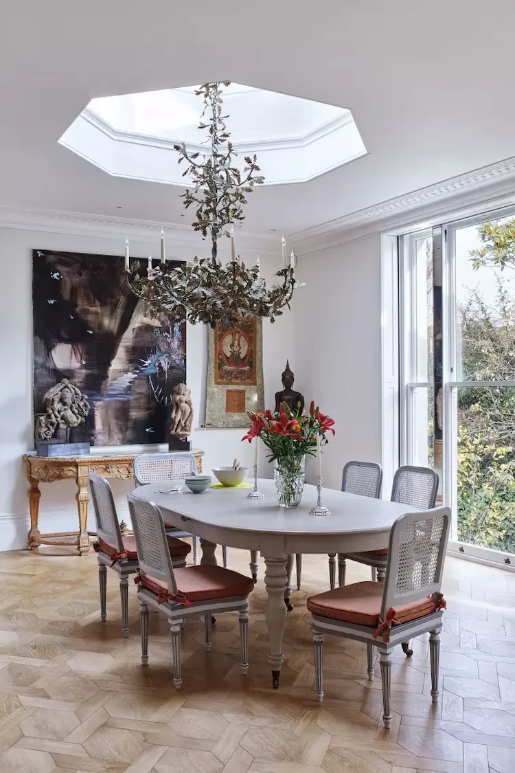 high quality chandelier as a focal point above dining table with antique dining chairs