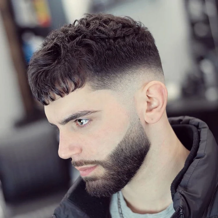 male hairstyle with faded sides of head and longer hair on top of head known as taper fade