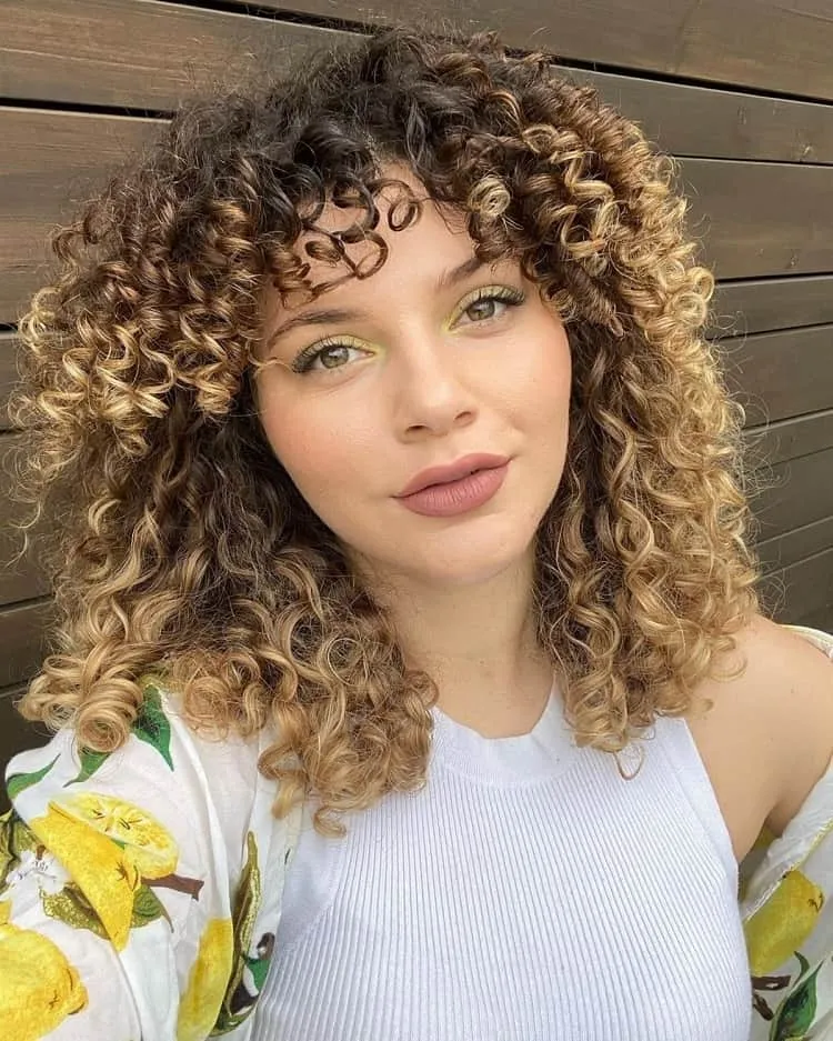 highlighted-curly-hair-with-bangs-and-layers
