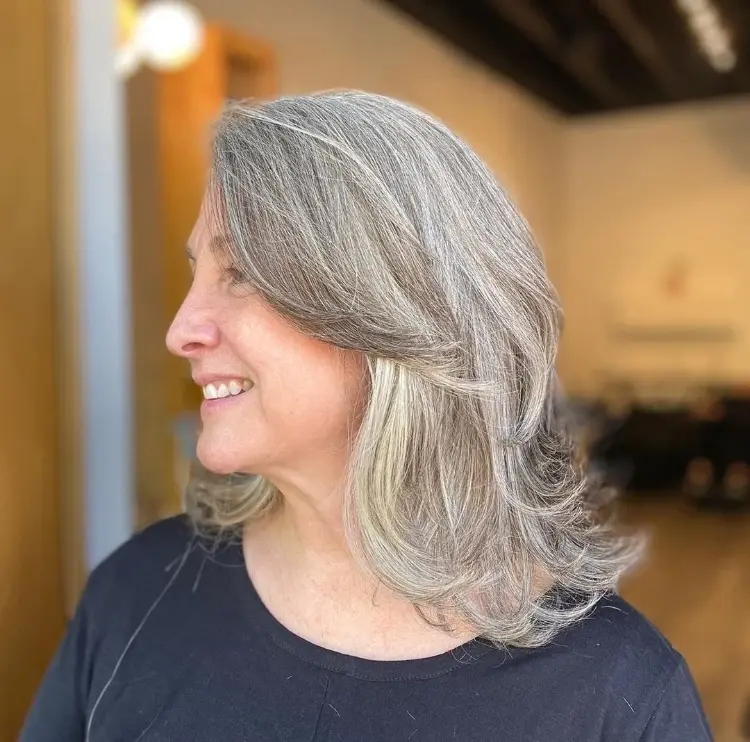 medium-length haircut with layers and long bangs women over 50