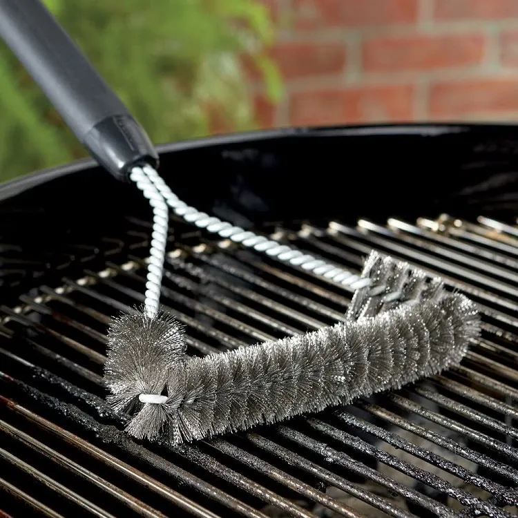 Cleaning-food-peaces-off-stainless-steel-grill-with-brush