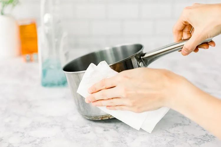Cleaning-grease-off-stainless-steel-pan-with-a-paper-towel