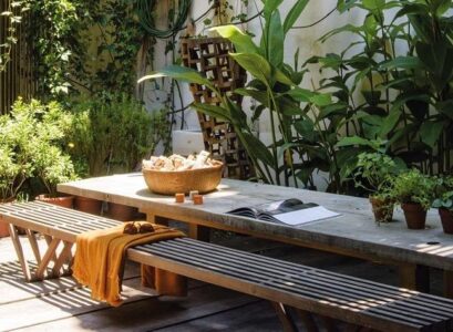 al fresco cover no grass backyaed wooden table bench greenery plants
