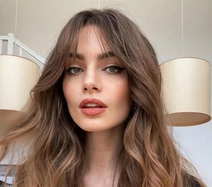 blow dry and round brush styling long hair with curtain bangs