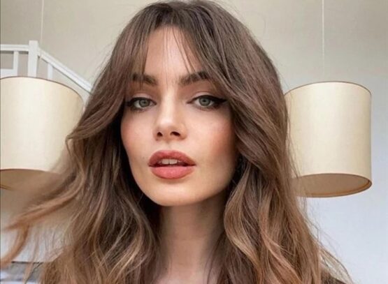 blow dry and round brush styling long hair with curtain bangs