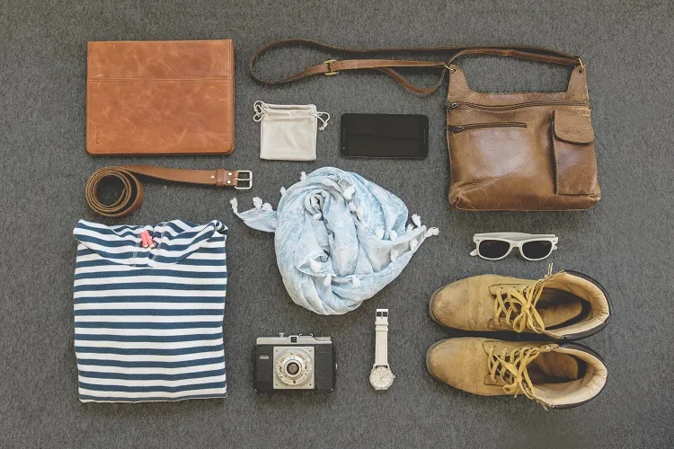 essential travel items walking shoos sunglasses camera
