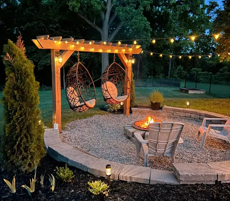 fire pit hanging egg chairs and lights for a cozy atmosphere