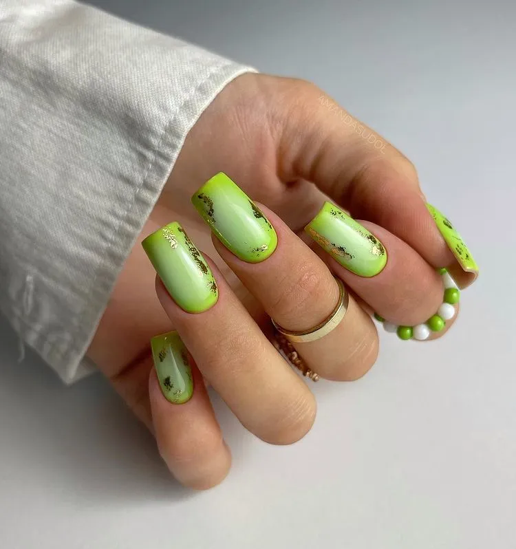 lime green nails with golden decorations