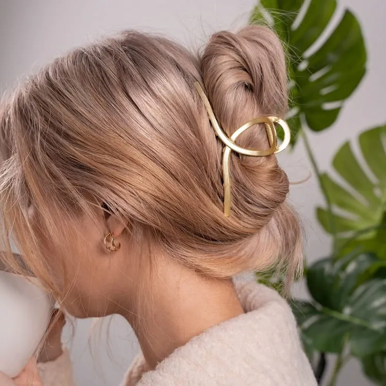 messy bun hairstyle gloden hair clip hairstyle