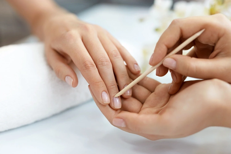 pushing back cuticles with special wooden stick