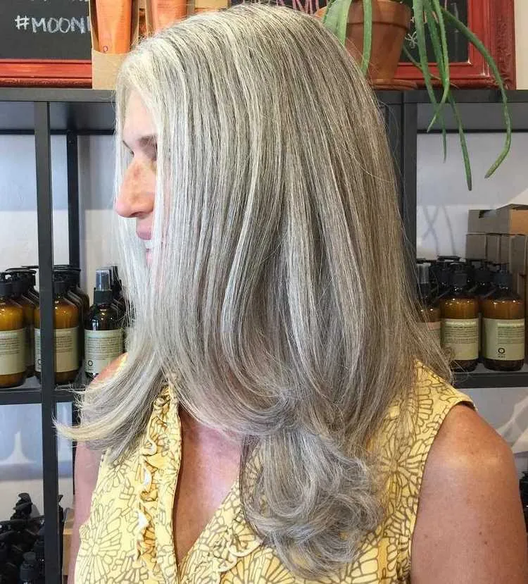 rejuvenating haircut with long layers for women over 50 with gray hair