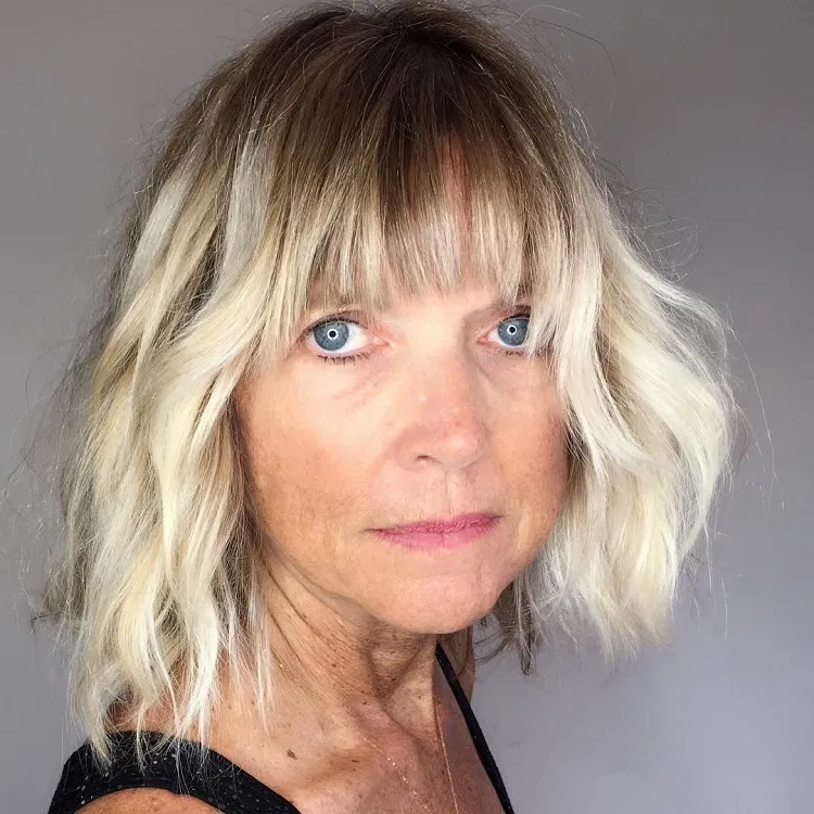 choppy layered long bob shaggy french bangs dark roots color transition medium length hairstyle for women over 60