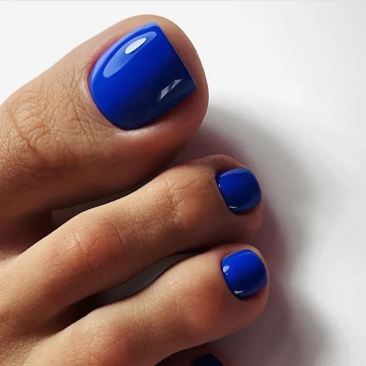 azul cobalto clásico de moda pedicura esmalte de uñas del dedo del pie tendencias piel bronceada