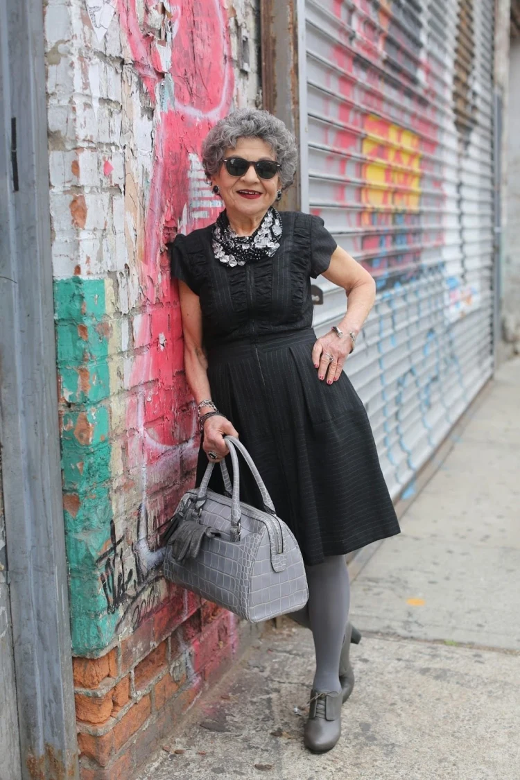 vestido negro hasta la rodilla y accesorios grises