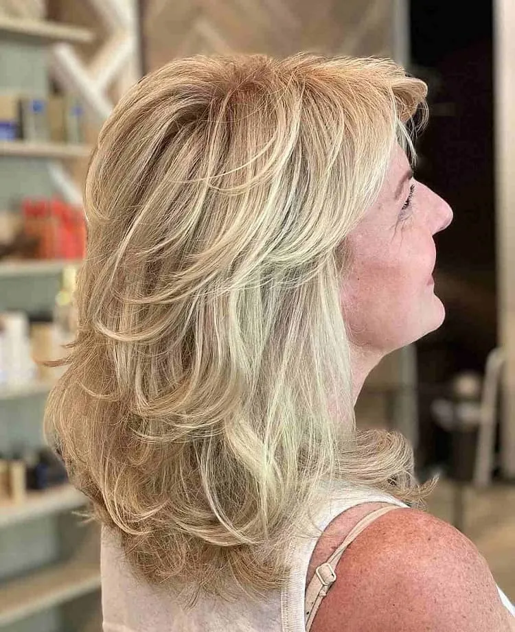 mid length blonde haircut with feathered layers for womn in their 40s
