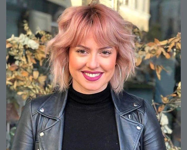 short layered haircut with curtain bangs in pastel pink