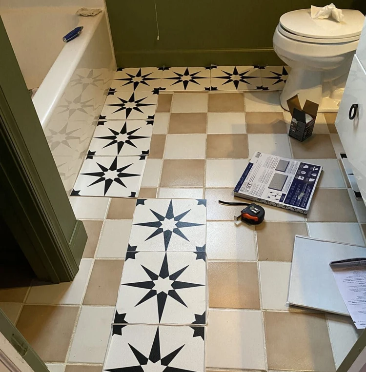 sticking adhesive tiles on ceramic ones in a bathroom