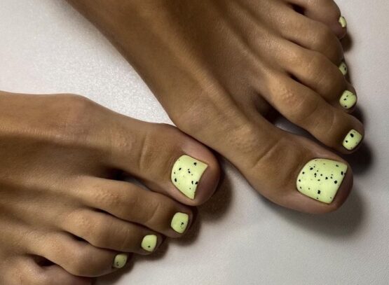yellow polish black splatter toe nail trends 2023