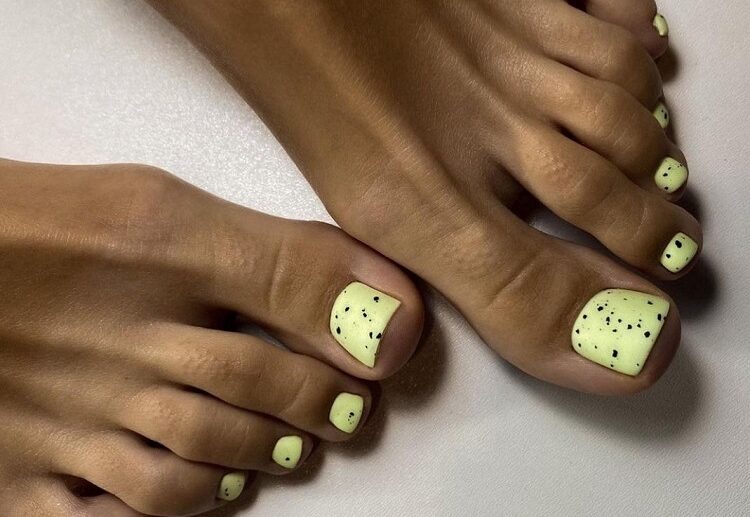 yellow polish black splatter toe nail trends 2023