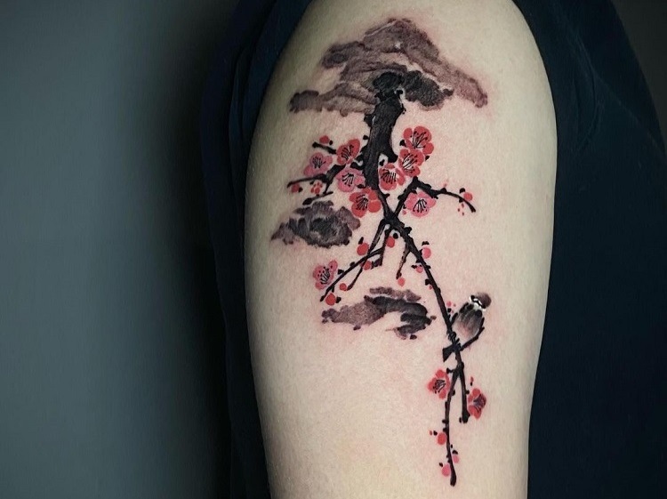 Minimalist cherry tattoo on the upper arm
