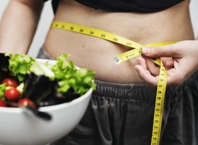woman measuring her tummy and weight
