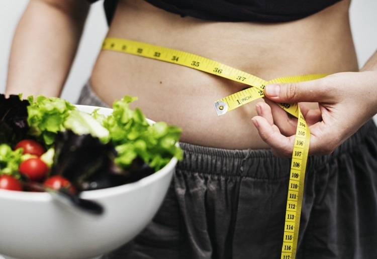 woman measuring her tummy and weight