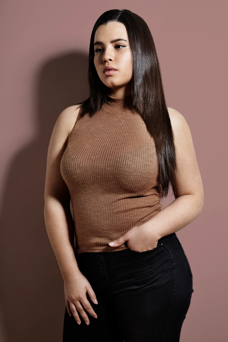 plus size woman wearing brown bodysuit and black jeans
