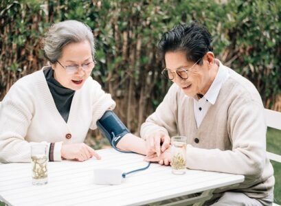 senior couple checking their blood pressure in the yard