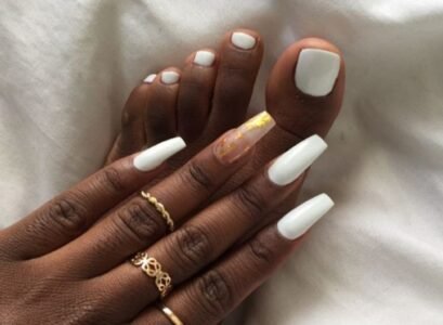 white matching manicure pedicure long ballerina nails gold rings dark skin woman