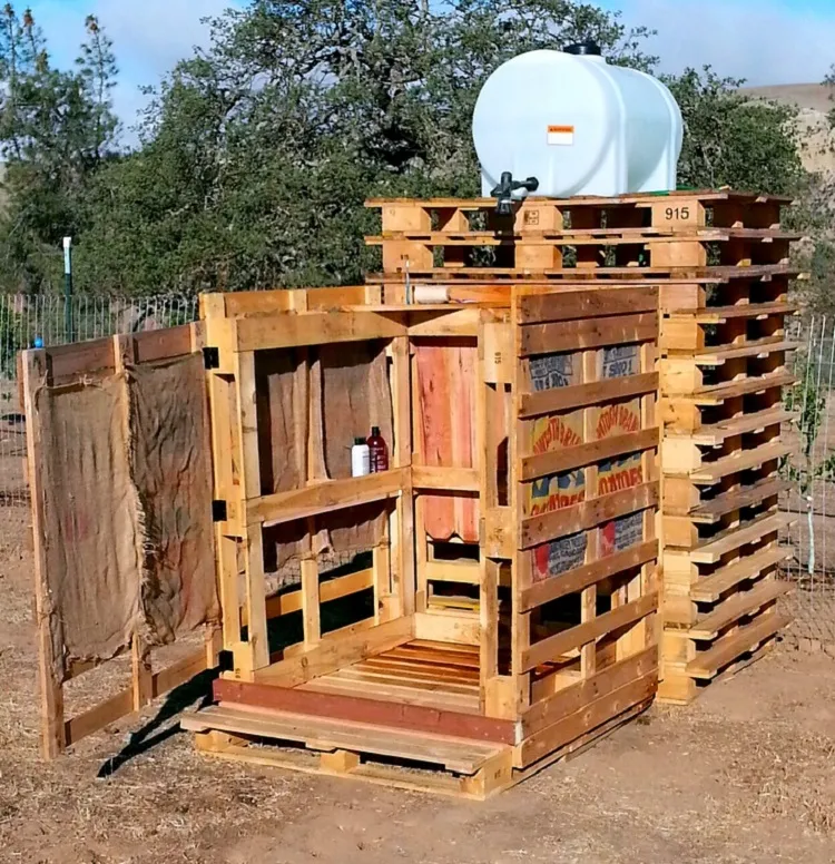 easy diy outdoor shower made with plastic tube with water and palletes