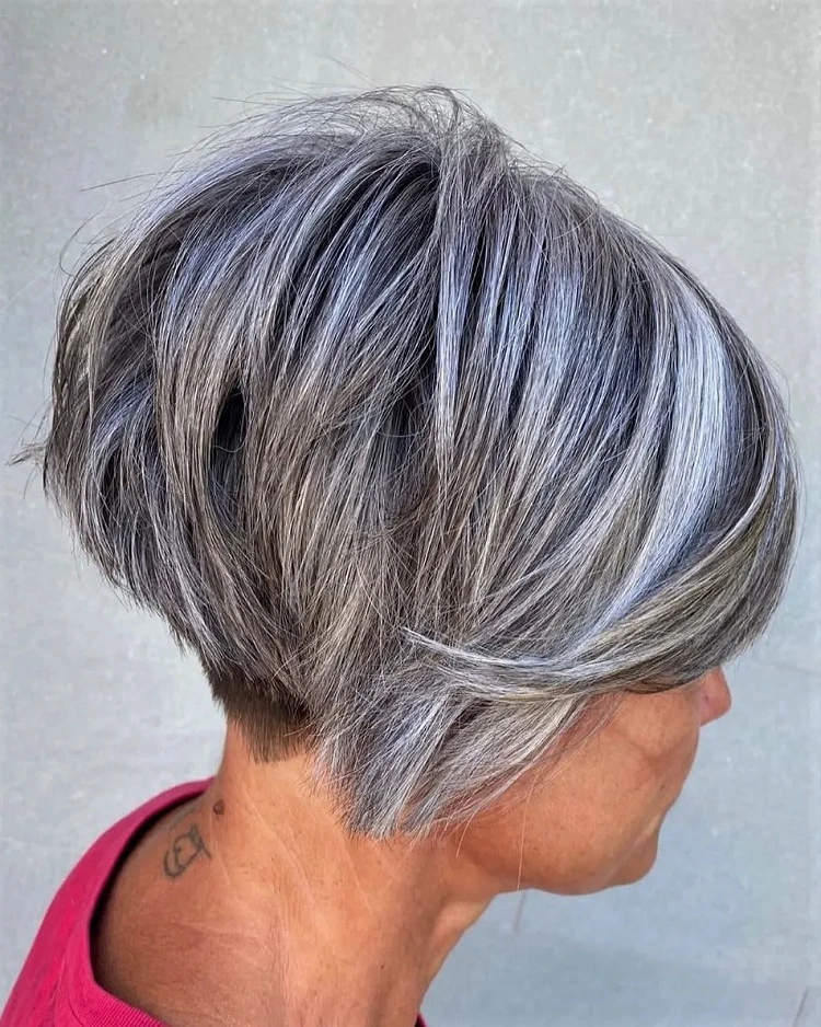 Corte de pelo bixie asimétrico para mujeres mayores de 60 años con flequillo lateral sal y pimienta.