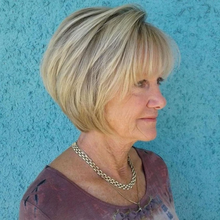 Corte de pelo bob invertido asimétrico para mujeres mayores de 60 años con flequillo