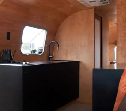 camper interior ideas wooden panelling black stainless steel kitchen sleek modern design