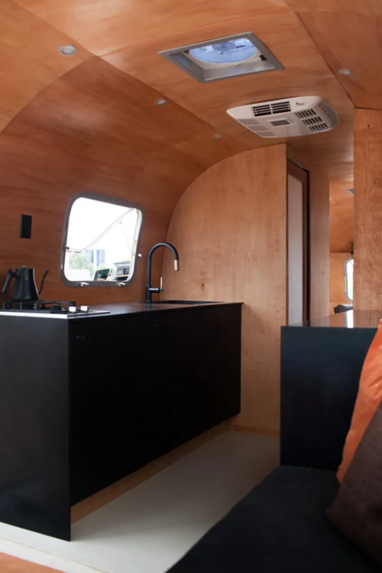 camper interior ideas wooden panelling black stainless steel kitchen sleek modern design