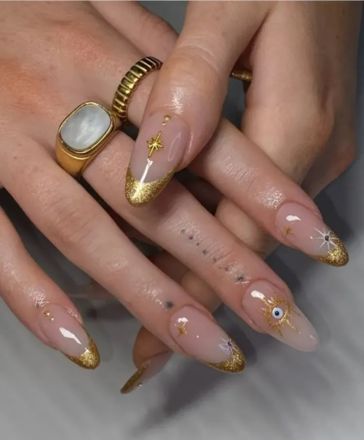 gold glitter french tips evil eye decoration leo season nails design inspo 2023