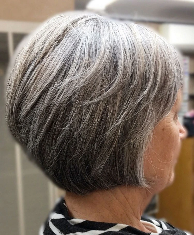 Corte de pelo bob invertido gris con capas entrecortadas para mujeres mayores de 60 años.