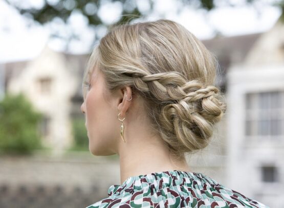 low braided bun hairstyle for a wedding guest 2023
