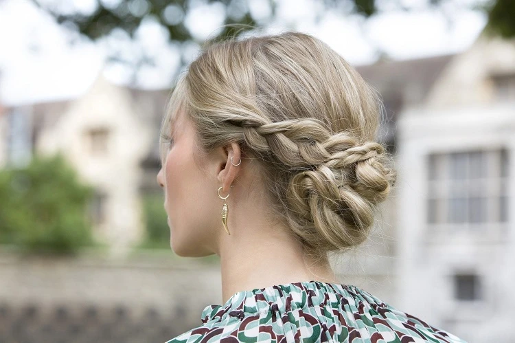 low braided bun hairstyle for a wedding guest 2023