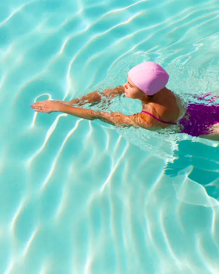 wear swimming cap to protect your hair color from chlorine swimming pool holidays summer 2023