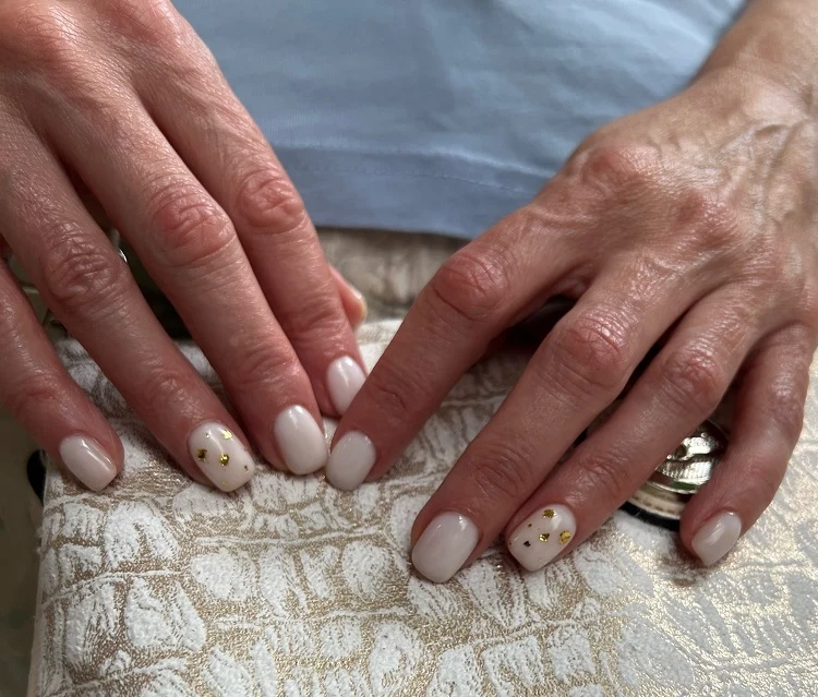 white milky nails with gold foil decoration for women over 50
