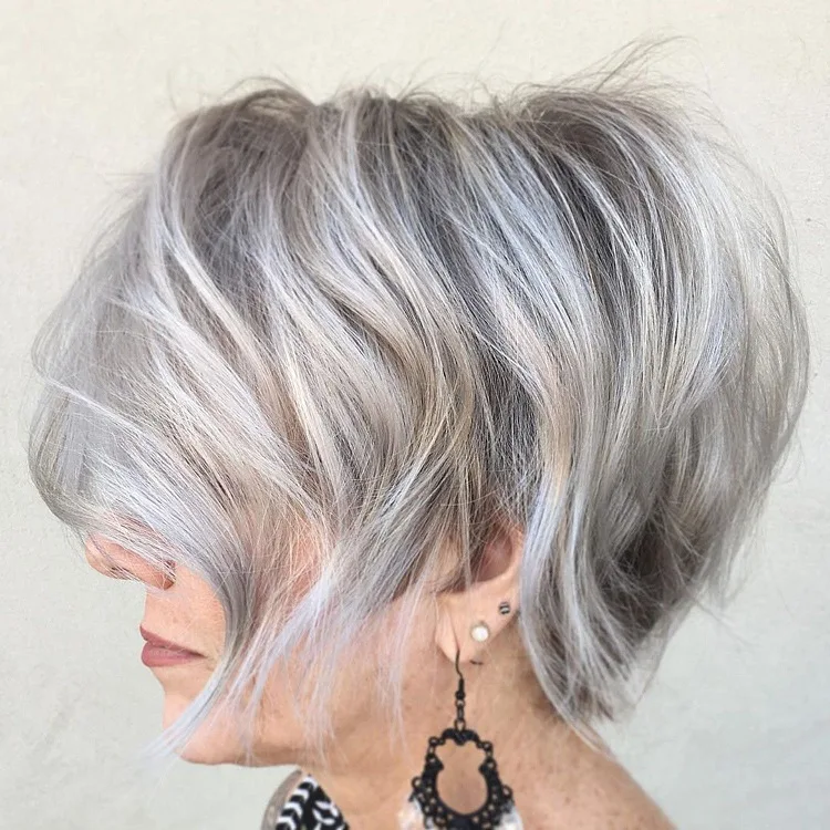 wispy salt and pepper bob haircut for women over 60 with bangs and layers